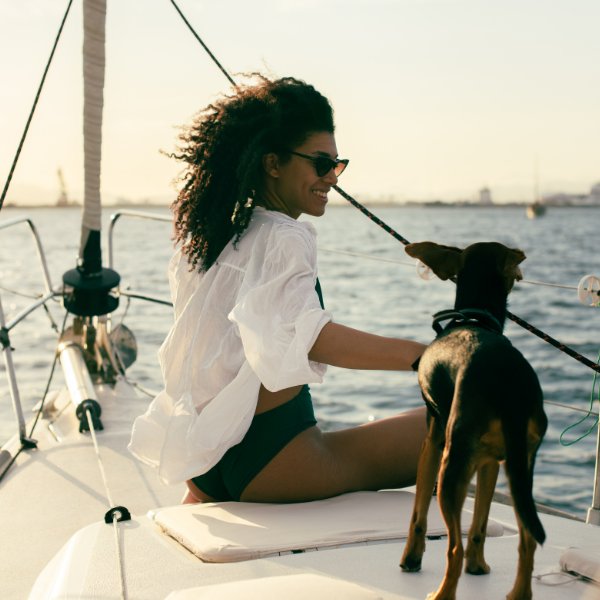 Woman and dog on the bow of a sailboat
