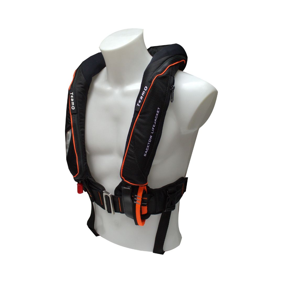 A black and orange Cruising Solutions TeamO PFD with BackTow™ - Offshore Black Hammar is shown on a white mannequin torso. The life jacket features visible straps, buckles, and the brand name printed on the shoulder against a plain background.