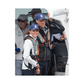 Two people in blue caps and sailing gear stand by a boat’s entrance, both wearing Cruising Solutions' TeamO PFD with BackTow™ – Offshore Black Hammar. Others in similar PFDs are seen nearby, getting ready for a boating activity.